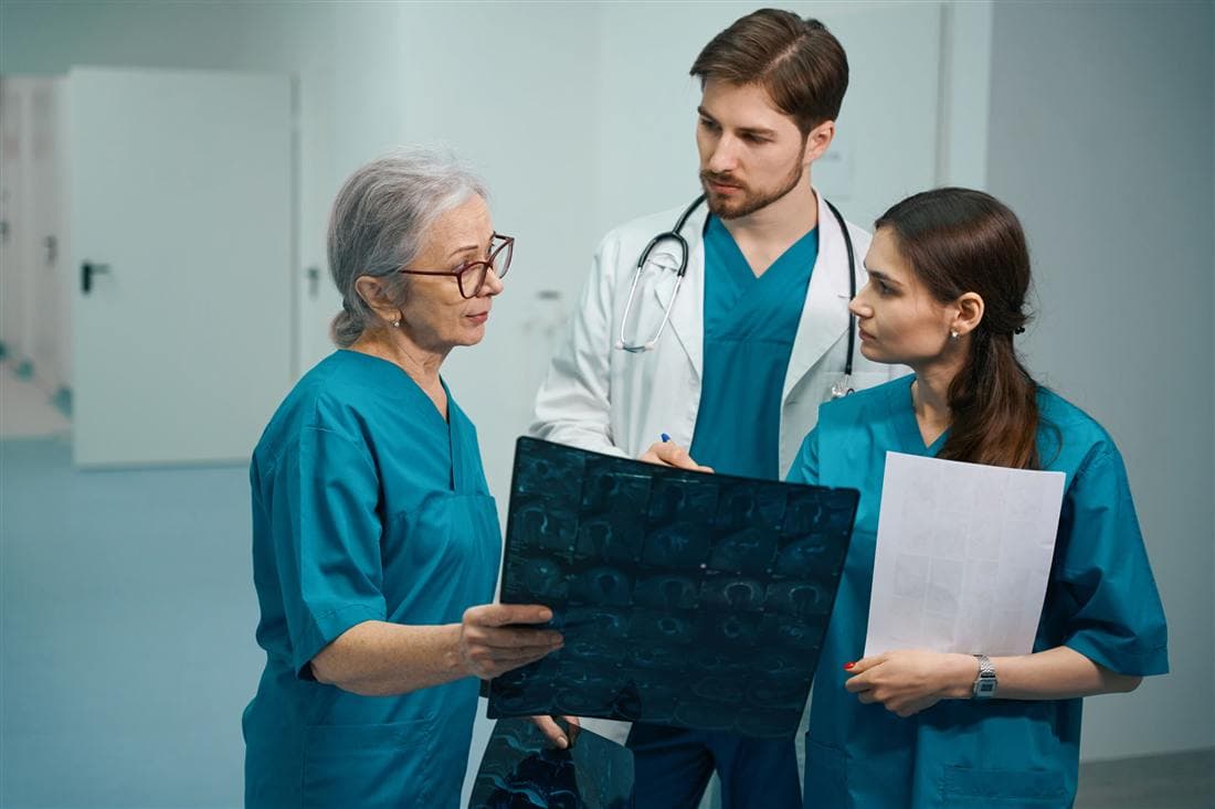 Grupo de médicos conversando en un pasillo de hospital